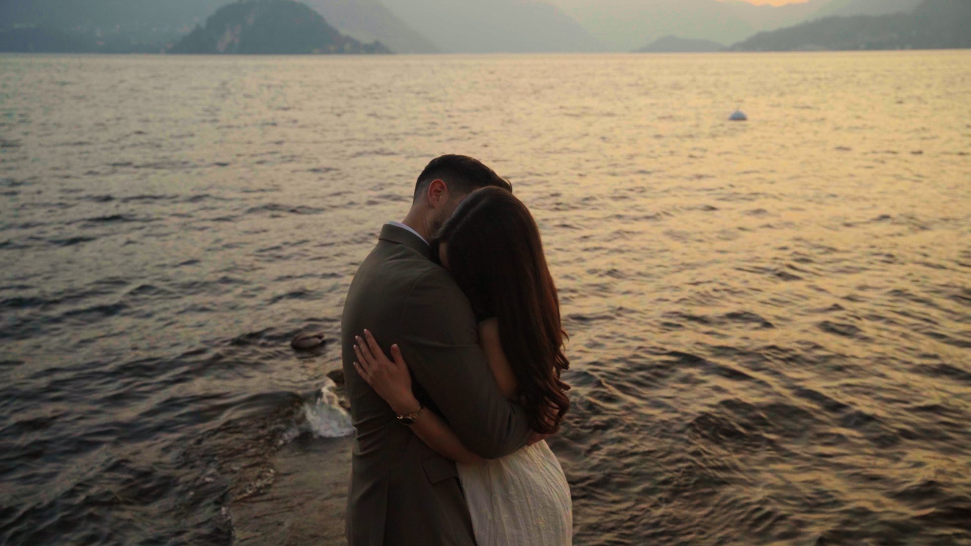 Pareja dándose un abrazo durante su preboda en el Lago di Como al atardecer