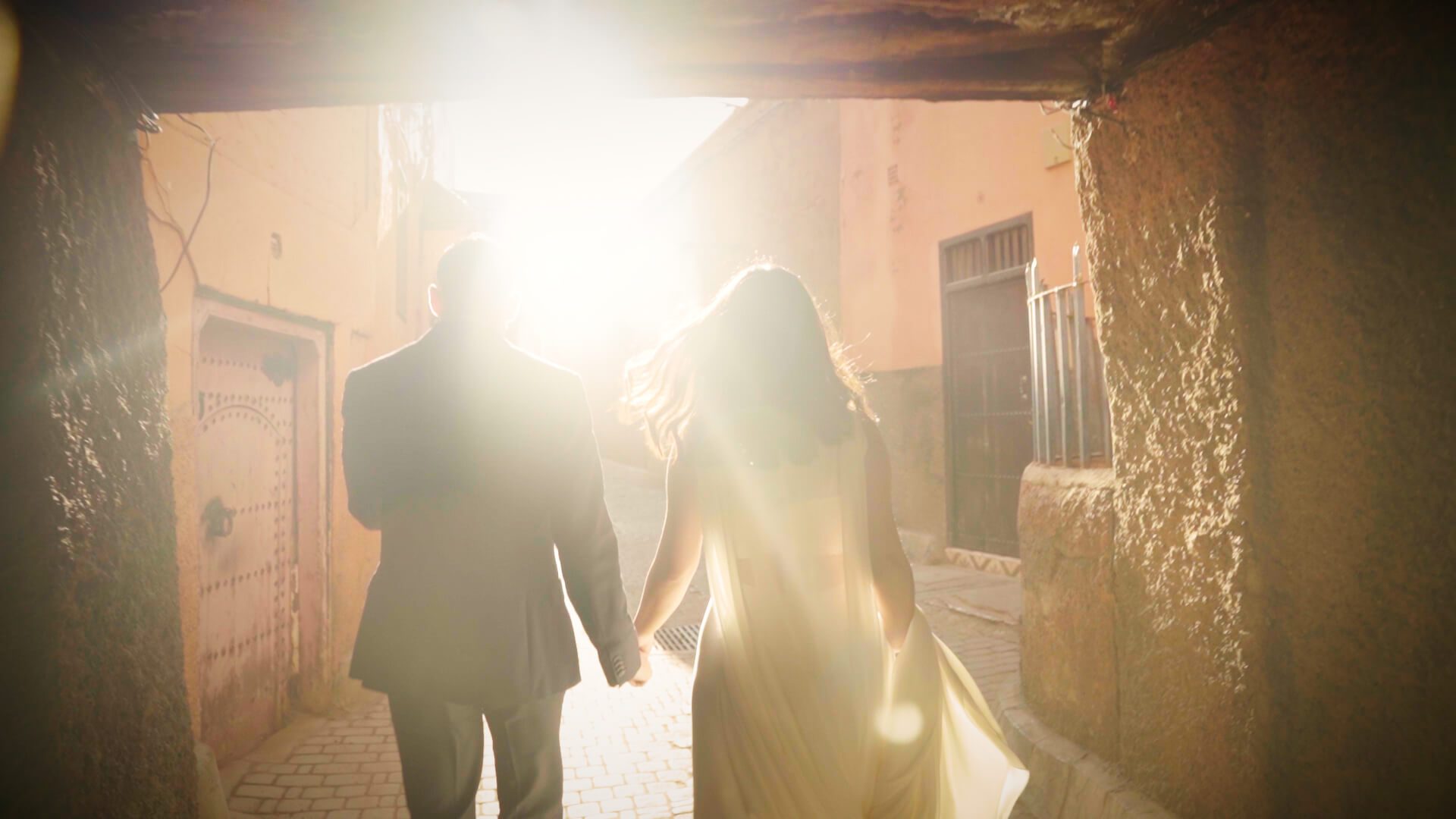 Novios caminando por las calles de Marrakech durante su sesión de postboda al amanecer